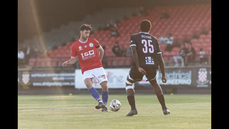 Cầu thủ Melbourne Knights đang chiến đấu với cầu thủ Brunswick City trên sân cỏ